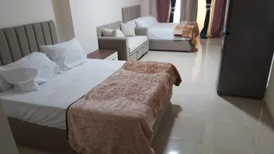 a hotel room with two beds and a couch at Tiba Golden Resort in Hurghada