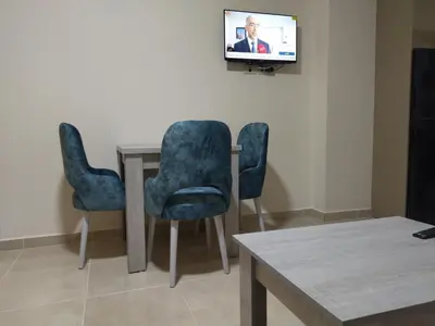 two chairs and a table with a tv on a wall at Tiba Golden Resort apartment 167 in Hurghada
