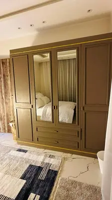 a large wooden cabinet with a bed inside of it at Hasnaa apartment in Hurghada