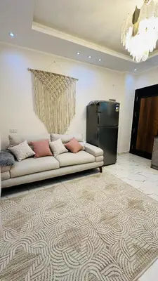 a living room with a couch and a refrigerator at Hasnaa apartment in Hurghada