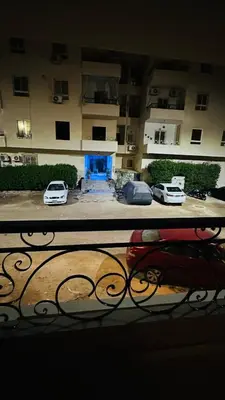 a view of a building with cars parked in a parking lot at Hasnaa apartment in Hurghada
