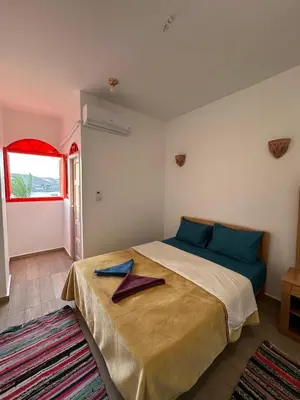 a bedroom with a bed with blue pillows on it at Palm Guest House in Aswan