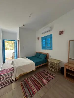 a bedroom with a bed and a table with a rug at Palm Guest House in Aswan