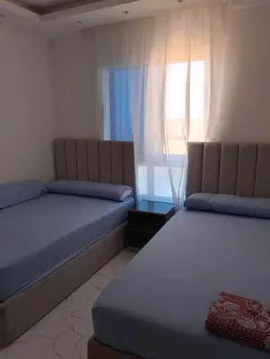 two beds in a room with a window at Fanadir bay in Hurghada