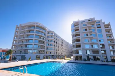 two large buildings with a swimming pool in front of a building at Scandic Resort Hurghada in Hurghada