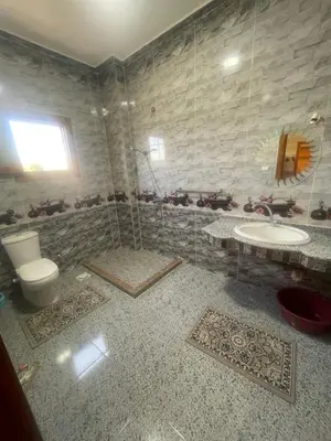 a bathroom with a toilet and a sink at Tonys Flat in Al Aqālitah