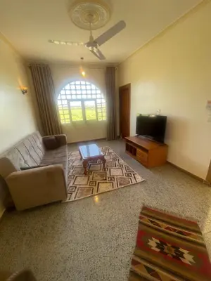 a living room with a couch and a tv at Tonys Flat in Al Aqālitah
