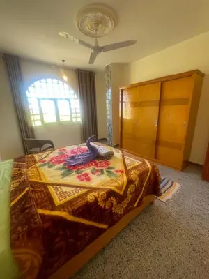 a bedroom with a bed and a dresser at Tonys Flat in Al Aqālitah