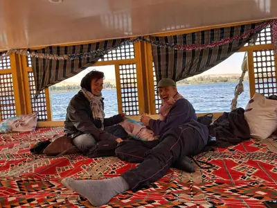 a group of people sitting on the floor of a boat at Hamdy's Felouque in Aswan