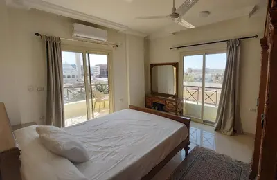 a bedroom with a bed and a large window at Hurghada Concierge at Casablanca Resort in Hurghada