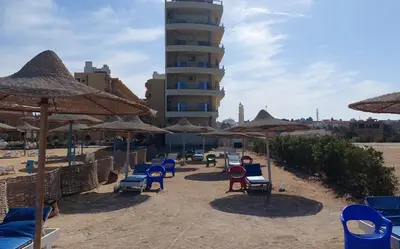 a group of chairs and umbrellas on a beach at Hurghada Concierge at Casablanca Resort in Hurghada
