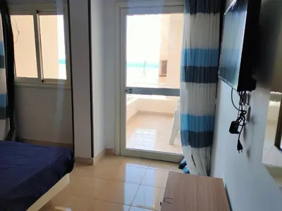 a room with a bed and a sliding glass door at Aquarium Seaview accomodations in Hurghada