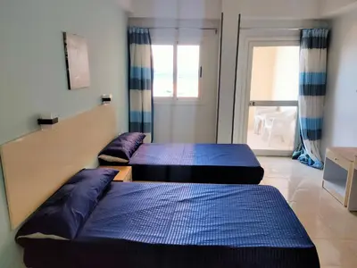 two beds sitting in a room with a door at Aquarium Seaview accomodations in Hurghada