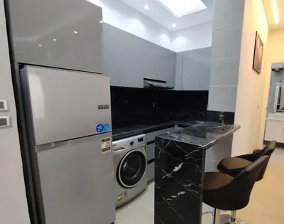a kitchen with a refrigerator and a washing machine at Sea view one bedroom apartment in Hurghada Dreams in Hurghada