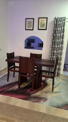 a wooden dining table and two chairs and a table and bench at Paradise Hill 207 in Hurghada