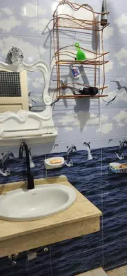 a bathroom with a sink and a bird on a shelf at Little Private Palace in Luxor in Luxor