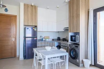 a kitchen with a table and a refrigerator at Gouna Getaway in Hurghada