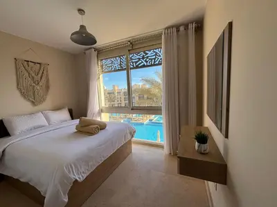 a bedroom with a bed and a large window at El gouna mangrouovy in Hurghada