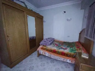 a small bedroom with a bed and a cabinet at جبل تقوق فيلا عبدالله محروس in Aswan
