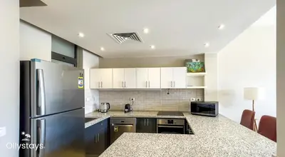 a kitchen with a stainless steel refrigerator and cabinets at Ollystays Tawila 3BR Townhouse Shared Pool in Hurghada