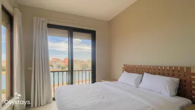 a bedroom with a bed and a large window at Ollystays Tawila 3BR Townhouse Shared Pool in Hurghada