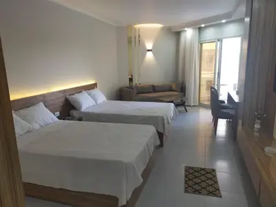 a hotel room with two beds and a couch at Scandic Resort Hurghada, Sea View in Hurghada