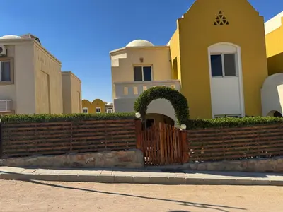 a house with a wooden gate and a fence at The getaway in Hurghada