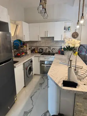 a kitchen with white cabinets and a dishwasher at The getaway in Hurghada