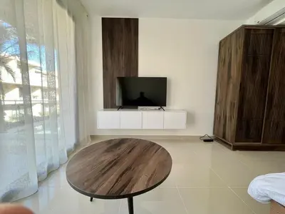 a living room with a table and a flat screen tv at Studio el Gouna holiday G cribs Compound in Hurghada