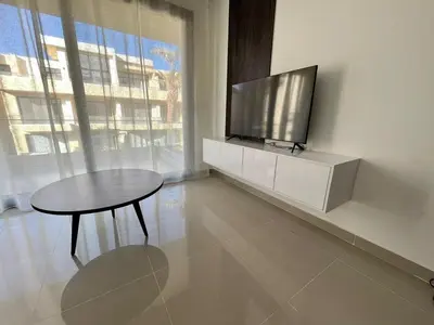 a living room with a table and a flat screen tv at Studio el Gouna holiday G cribs Compound in Hurghada
