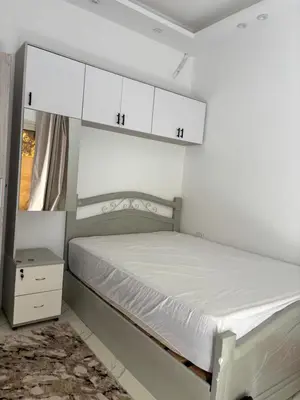 a bedroom with a bed and white cabinets at البلكان بيتش ريزورت Balkan Beach Resor in Hurghada