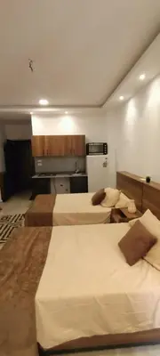 a hotel room with three beds and a kitchen at Hurghada Fiesta Resort Studio 323 in Hurghada