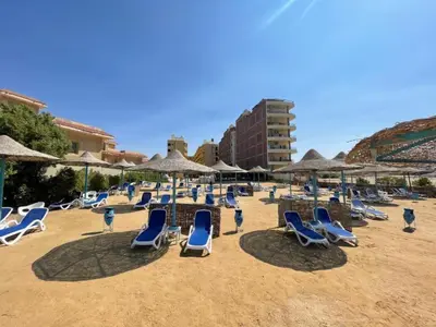 a bunch of chairs and umbrellas on a beach at Hurghada Fiesta Resort Studio 323 in Hurghada