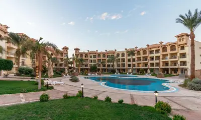 an apartment complex with a swimming pool and palm trees at Al Saraya Sahl Hasheesh by Peak -One-Bedroom Apartment C316 in Hurghada