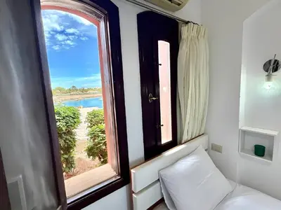 a room with a window with a view of a beach at Exquisite 1BR Chalet with Pool and Beach Front El Gouna in Hurghada