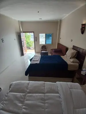 a hotel room with two beds and a couch at Nile Moon in Jazīrat Aswān