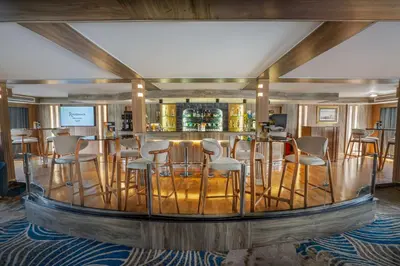 a bar in a room with chairs and a bar counter at Renaissance Nile Cruise - Every Saturday from Luxor To Aswan for 4 Nights , and every Wednesday from Aswan To Luxor for 3 Nights in Luxor