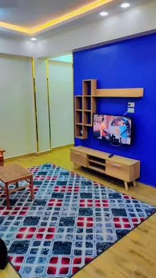 a living room with a blue wall and a tv at Hurghada in Hurghada