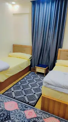 a room with two beds and a blue curtain at Hurghada in Hurghada