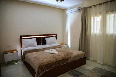 a bedroom with a bed with two towels on it at Peaceful Magawish Apartment in Hurghada