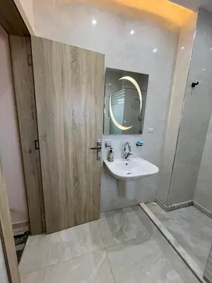 a bathroom with a sink and a mirror at Peaceful Magawish Apartment in Hurghada