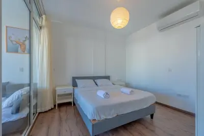 a white bedroom with a bed and a mirror at Modern 1BR with Pool View in Sholan El Gouna in Hurghada