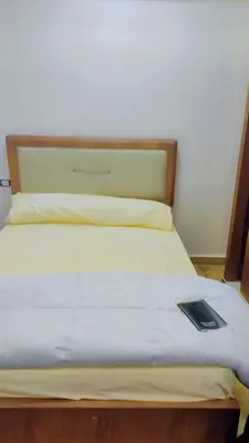 a bed with a wooden headboard and a book on it at Carrefour Hurghada city centre in Hurghada