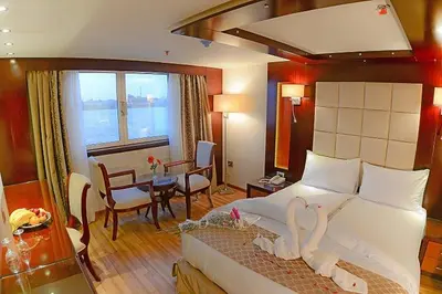 a bedroom with a bed with swans on it at King of The Vally Nile Cruise Aswan To Luxor 3 Night And visit the Nubian village in Aswan