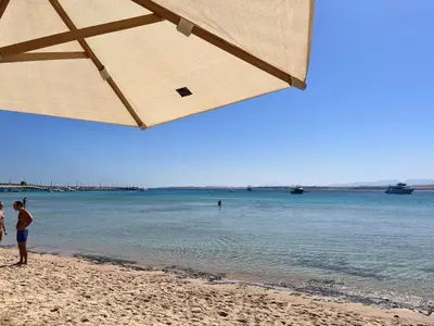 a group of people standing on a beach at A dream with a sea view in Azzurra in Hurghada