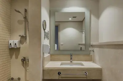 a bathroom with a sink and a mirror at Modish & Modern 1BDR Poolfront Mangroovy Free Pool & Beach in Hurghada