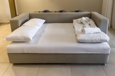 a couch with two towels on top of it at Modish & Modern 1BDR Poolfront Mangroovy Free Pool & Beach in Hurghada