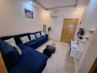 a living room with a blue couch and a television at ميراج باى in Hurghada