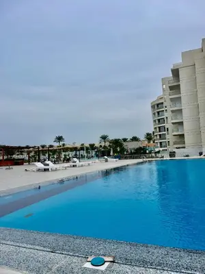 a woman laying on the beach next to a swimming pool at Scandic Resort Hurghada in Hurghada