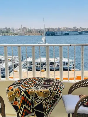 a table and chairs on a balcony overlooking the water at Toutankhamon in Luxor